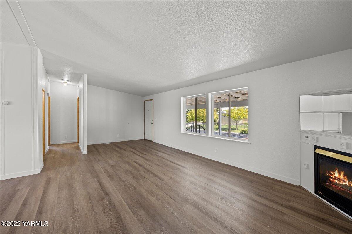 1200 South Euclid Road, Unit 84 Grandview, WA 98930 - Photo 6 of 24 a view of an empty room with wooden floor and a window