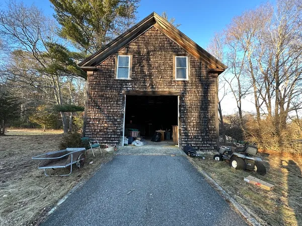 a view of a house with yard and parking area