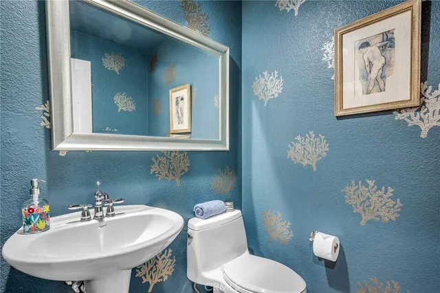 a bathroom with a toilet a sink and mirror