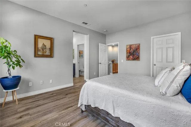 a bedroom with a large bed and a potted plant