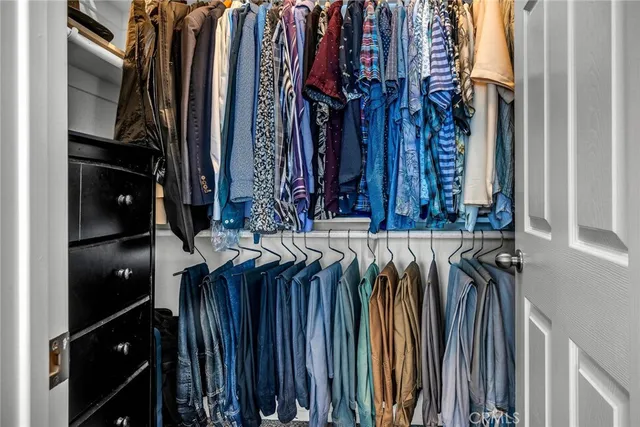 a view of walk in closet with clothes