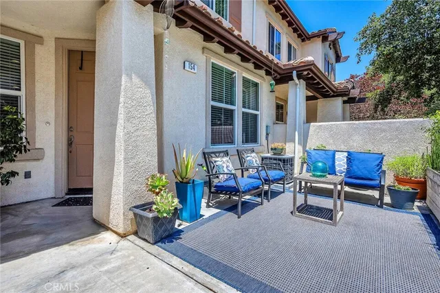 a view of patio with a table and chairs and potted plants