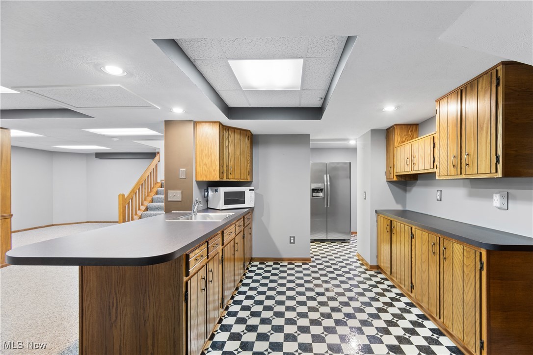 2317 Raintree Street Northeast Canton, OH 44705 - Photo 30 of 40 Kitchen with light floors, stainless steel refrigerator with ice dispenser, dark countertops, a peninsula, and recessed lighting