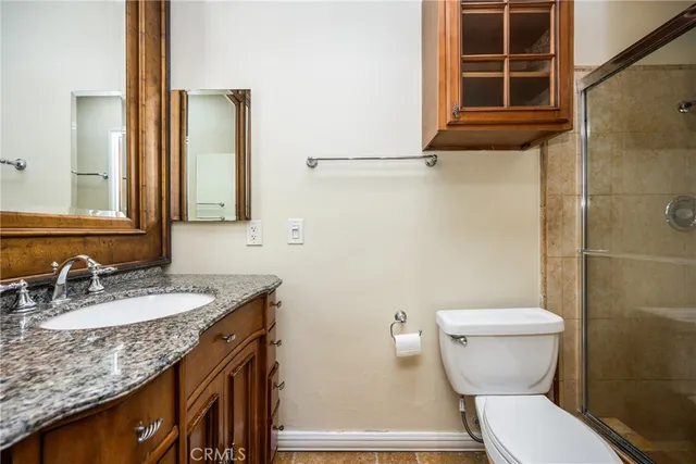 a large white kitchen with granite countertop a lot of counter space and a wooden floor