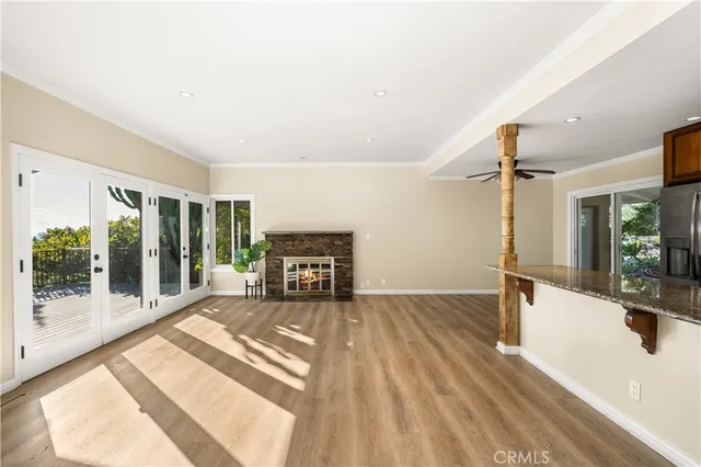 a kitchen with stainless steel appliances granite countertop a refrigerator a stove and a sink with wooden floor