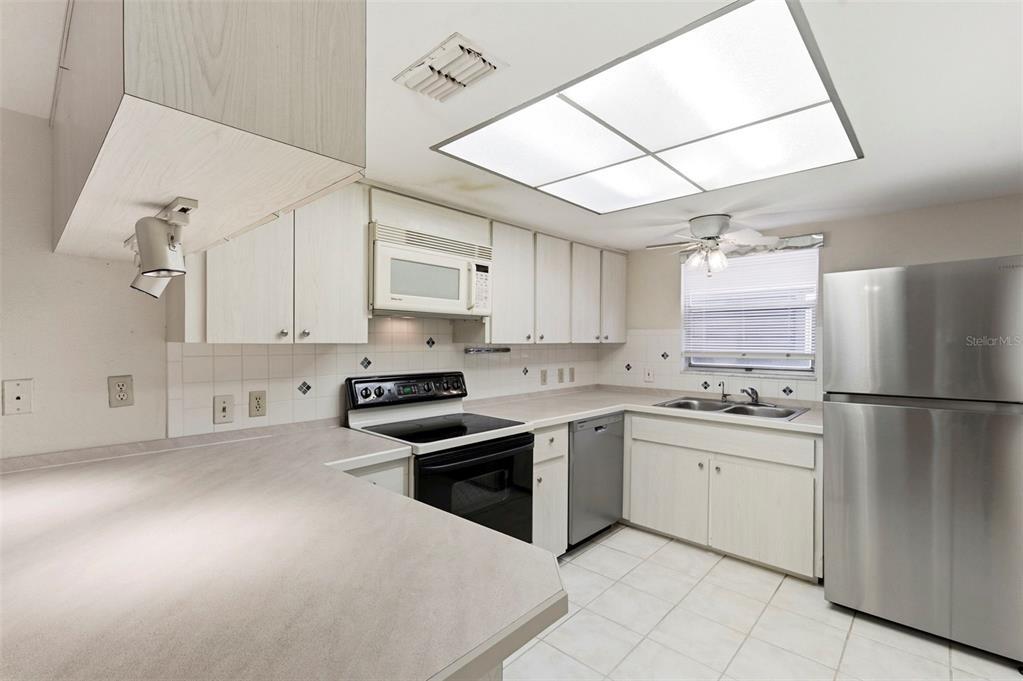 4101 Passport Lane, Unit 203 New Port Richey, FL 34653 - Photo 11 of 83 a kitchen with stainless steel appliances granite countertop a sink stove and refrigerator