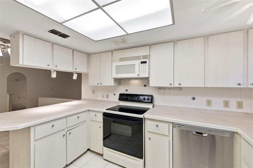 4101 Passport Lane, Unit 203 New Port Richey, FL 34653 - Photo 14 of 83 a kitchen with granite countertop white cabinets and white appliances