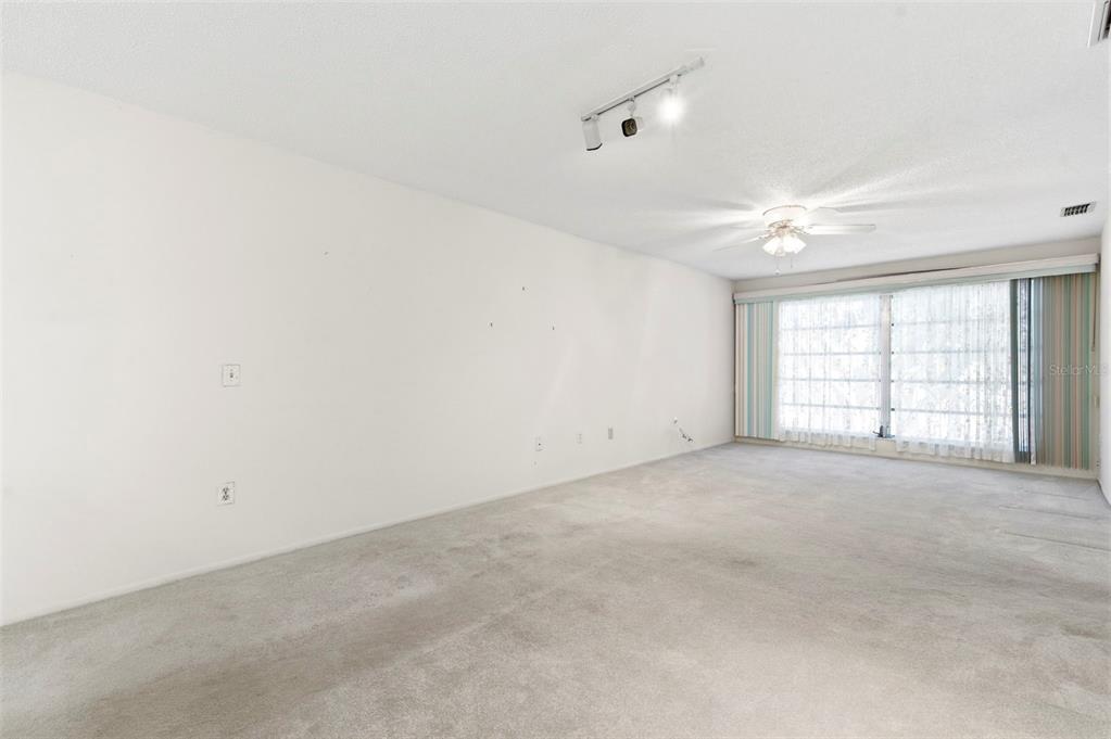 4101 Passport Lane, Unit 203 New Port Richey, FL 34653 - Photo 23 of 83 an empty room with windows and chandelier fan