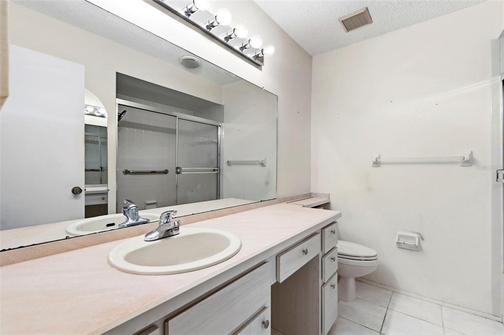 4101 Passport Lane, Unit 203 New Port Richey, FL 34653 - Photo 31 of 83 a bathroom with a sink toilet and mirror