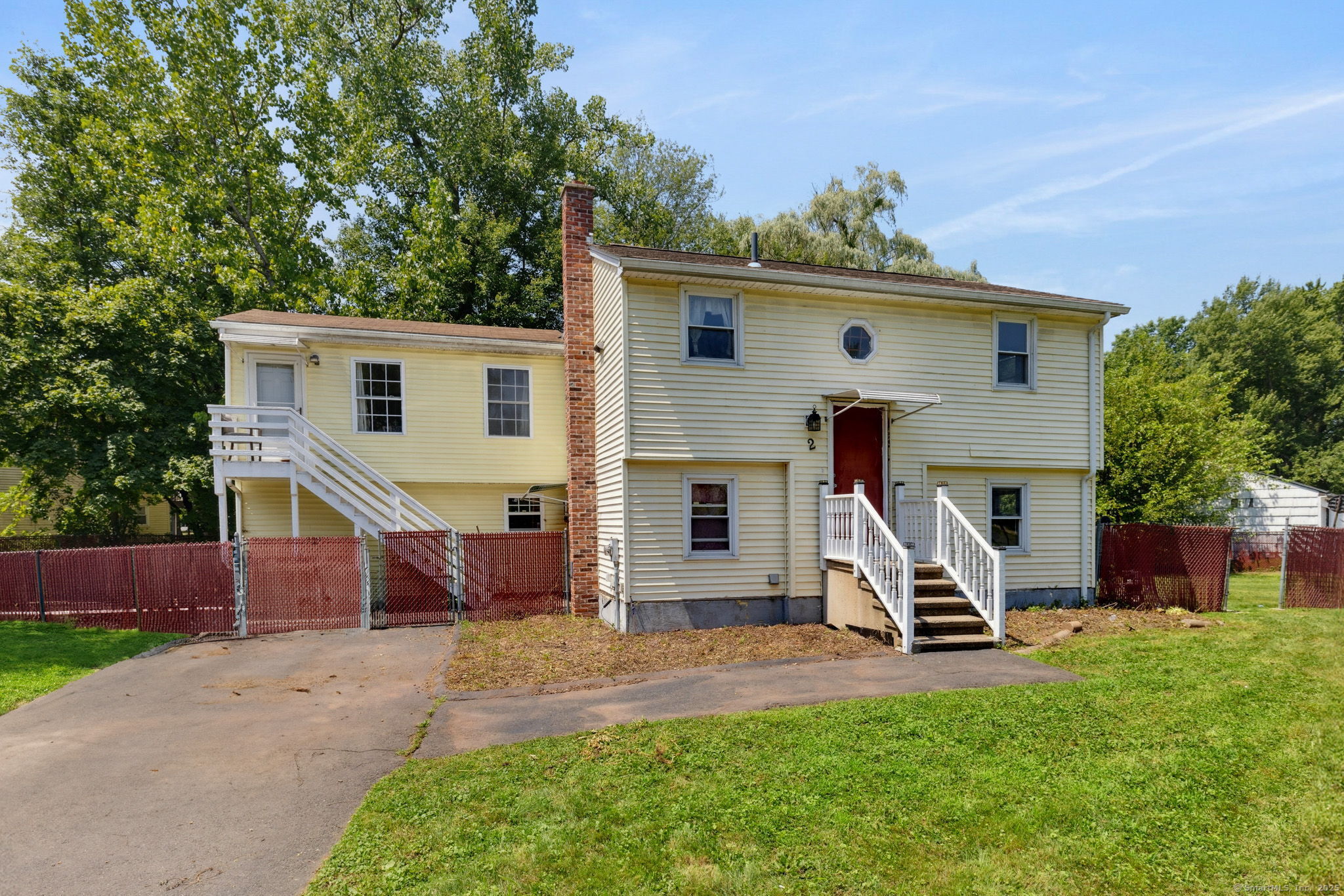 a view of a house with backyard and a tree