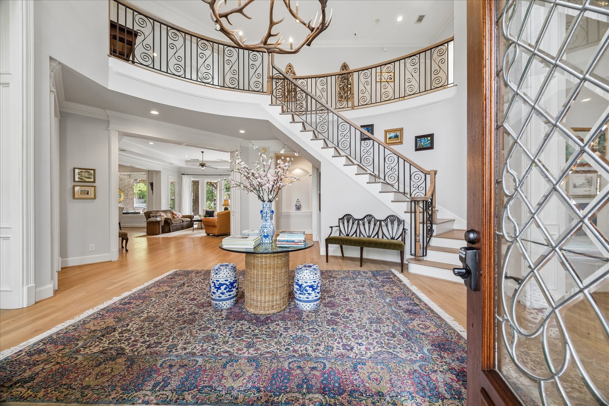11421 Whippoorwill Road Houston, TX 77024 - Photo 2 of 33 Impressive two-story foyer featuring a dramatic wrought iron staircase and soaring ceilings. This bright, inviting entrance showcases the home's meticulous craftsmanship and provides a seamless flow into the formal dining and living areas.