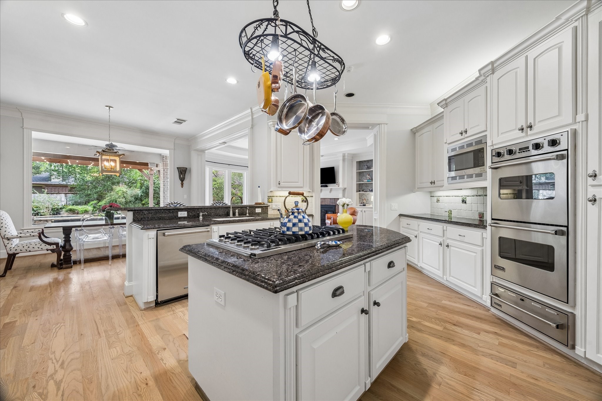 11421 Whippoorwill Road Houston, TX 77024 - Photo 3 of 33 Designer kitchen featuring Viking double ovens, 6-burner gas island cooktop, Sub-Zero fridge, and Cove dishwasher. Complete with granite surfaces, under-cabinet lighting, and a decorative pot rack, this space is the functional heart of the home.