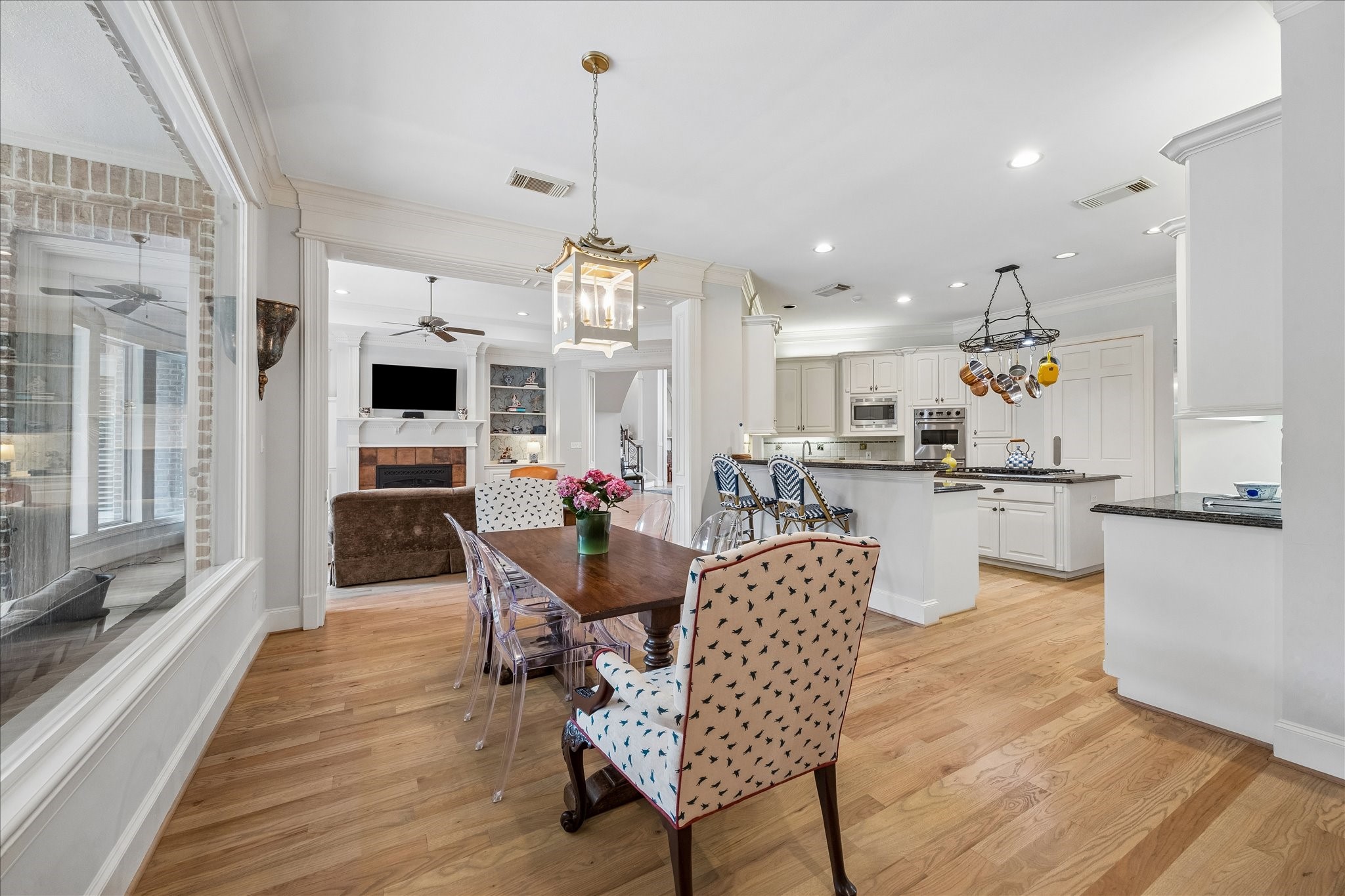 11421 Whippoorwill Road Houston, TX 77024 - Photo 5 of 33 Cheerful breakfast room featuring a grand view of the backyard oasis. Perfectly positioned off the kitchen, this light-filled space boasts a designer light fixture, crown molding, and an open layout designed for modern living.
