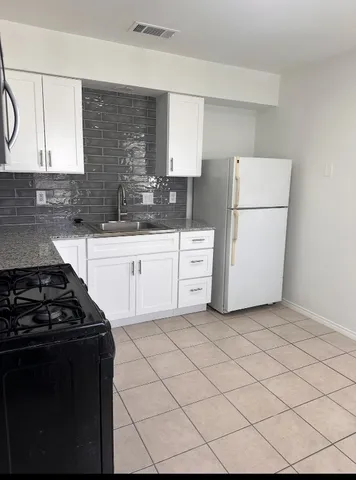 a kitchen with cabinets and white stove