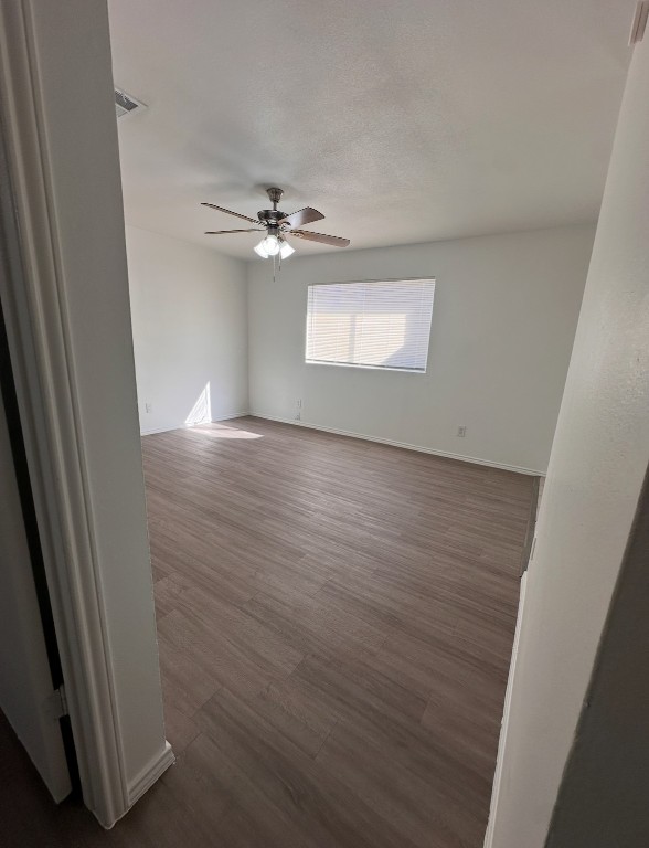 6910 Circle S Road, Unit B Austin, TX 78745 - Photo 6 of 10 an empty room with wooden floor chandelier fan and windows