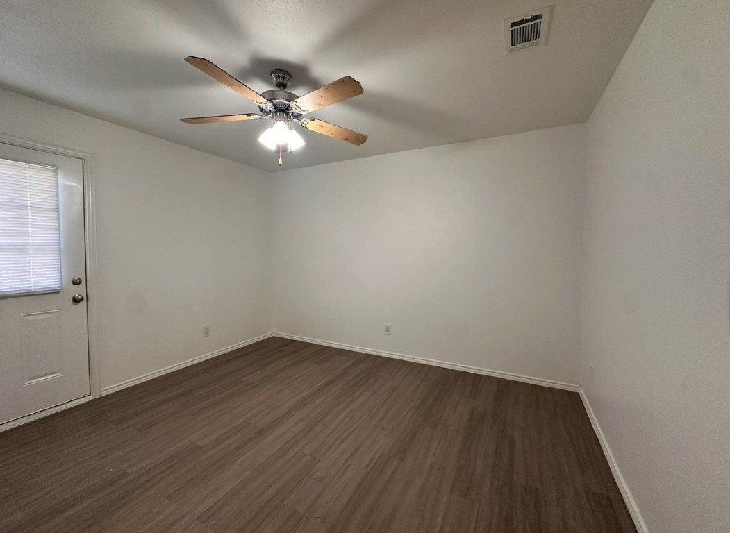 6910 Circle S Road, Unit B Austin, TX 78745 - Photo 9 of 10 an empty room with wooden floor fan and windows