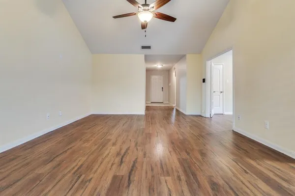wooden floor in an empty room with a fan