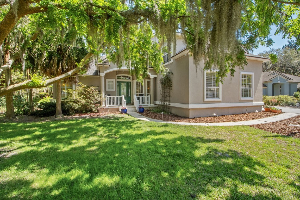 Charming corner-lot setting framed by mature trees and lush landscaping in the desirable Azalea Pointe community.