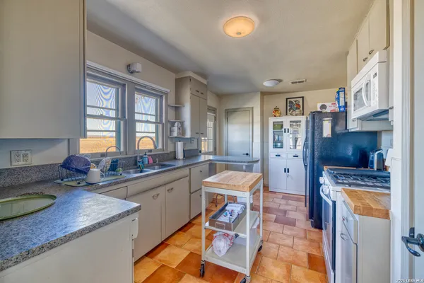 a kitchen with granite countertop a sink cabinets and window