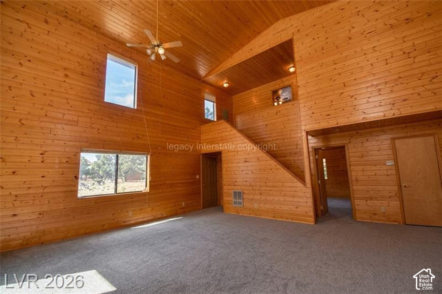 1129 Ponderosa Road, Unit 40 Hatch, UT 84735 - Photo 9 of 47 Vaulted wood-paneled ceilings with ceiling fan, wood-paneled walls, multiple windows, and a built-in staircase