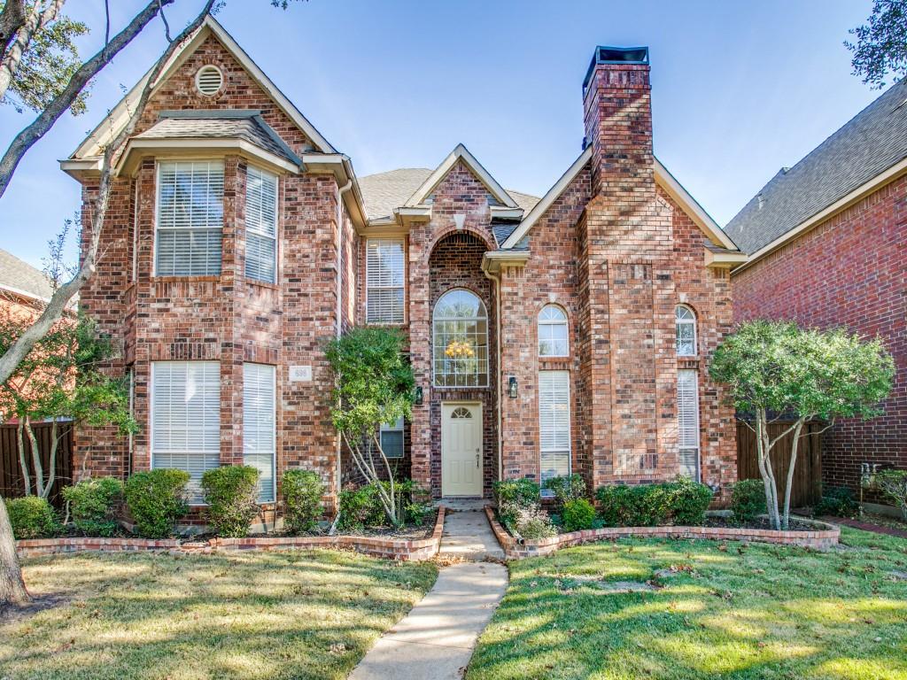 front view of a brick house with a yard