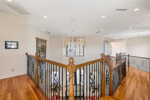 a view of a hallway with wooden floor and stairs