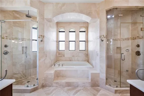 a spacious bathroom with a tub shower and mirror