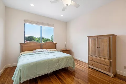 a bedroom with a large bed and wooden floor