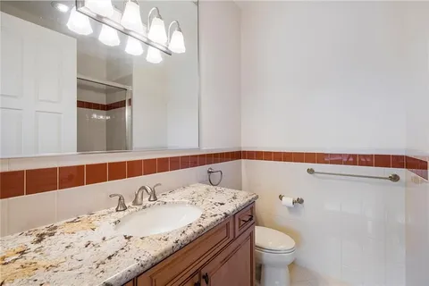 a bathroom with a sink a toilet and a mirror