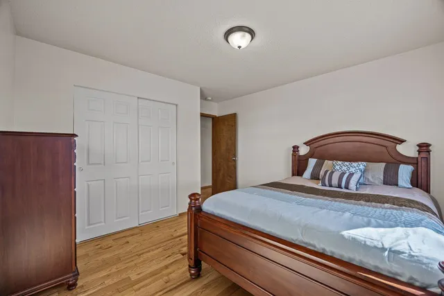 a bedroom with a bed and wooden floor