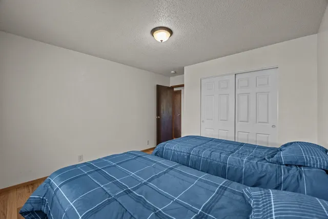 a bedroom with a bed and a lamp with wooden floor