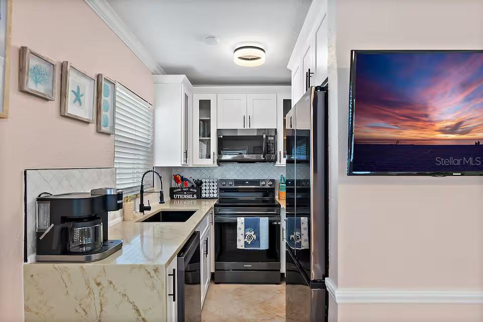 724 Gulf Boulevard Indian Rocks Beach, FL 33785 - Photo 16 of 55 a kitchen with a stove and a microwave