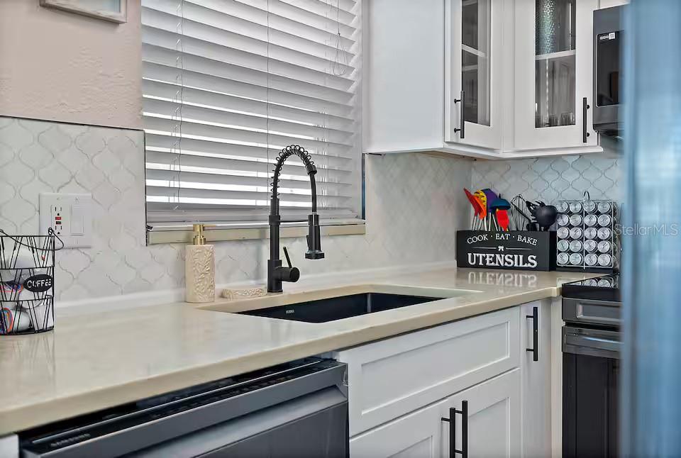 724 Gulf Boulevard Indian Rocks Beach, FL 33785 - Photo 17 of 55 a kitchen with stainless steel appliances a sink and cabinets