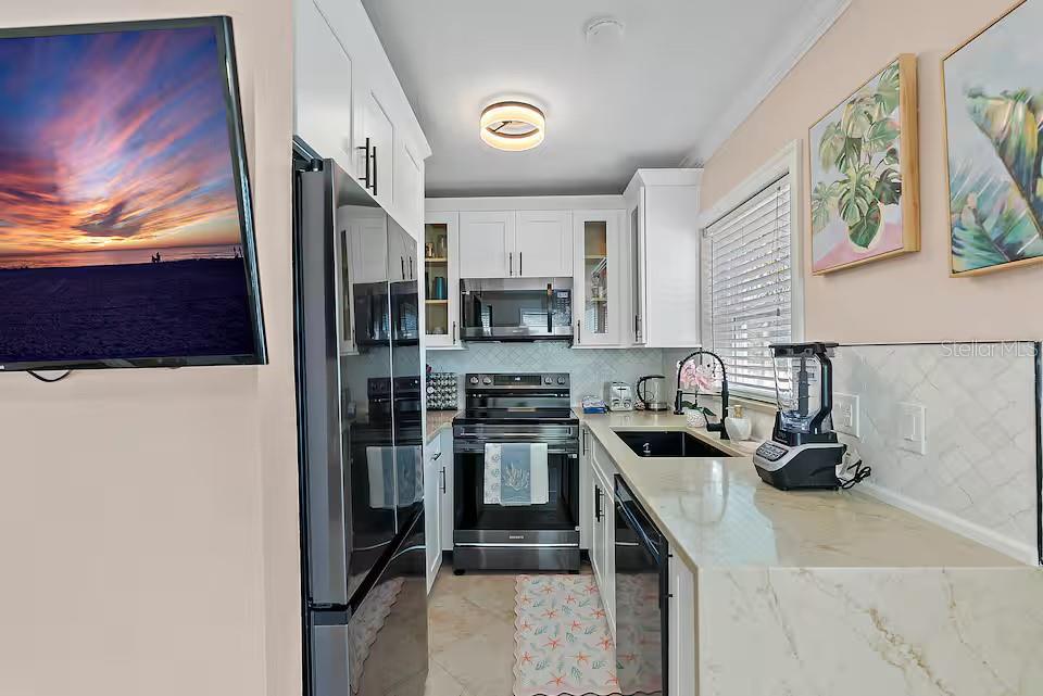 724 Gulf Boulevard Indian Rocks Beach, FL 33785 - Photo 28 of 55 a kitchen with stainless steel appliances granite countertop a stove a sink and a refrigerator
