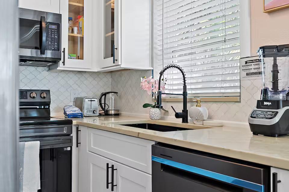 724 Gulf Boulevard Indian Rocks Beach, FL 33785 - Photo 29 of 55 a kitchen with stainless steel appliances granite countertop a sink and cabinets