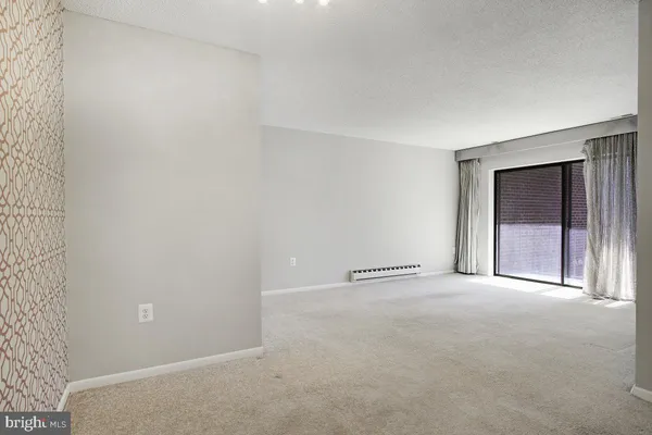 an empty room with a bench and mirror
