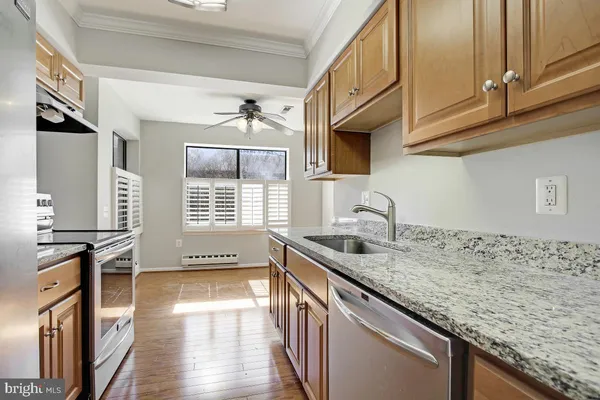 a kitchen with stainless steel appliances granite countertop a sink stove and cabinets