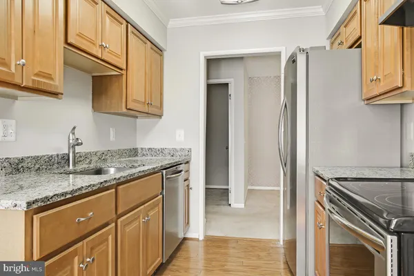 a kitchen with stainless steel appliances granite countertop a sink stove and cabinets