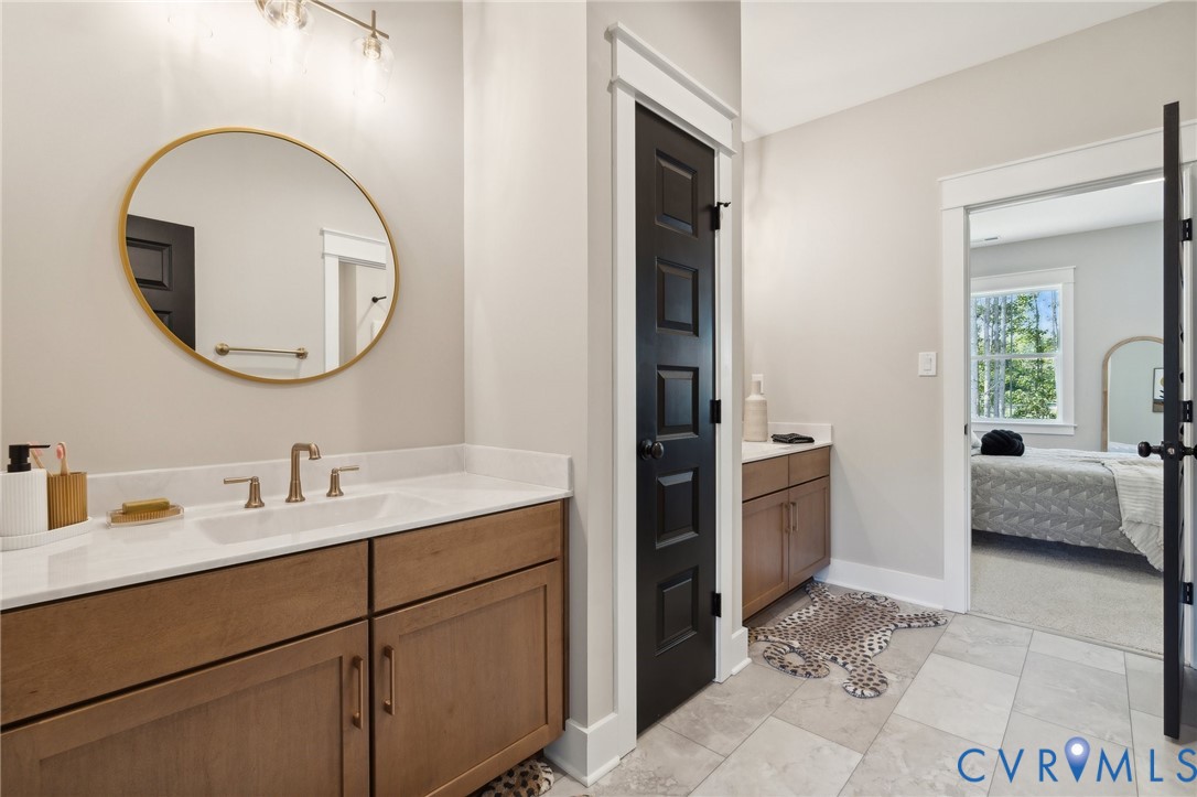 4976 Gooden Trail Quinton, VA 23141 - Photo 32 of 49 a en suite bathroom with a double vanity sink and a mirror