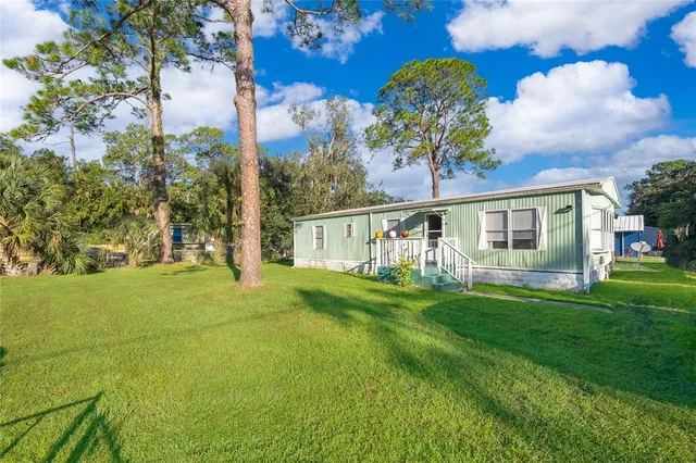 a view of a house with a backyard