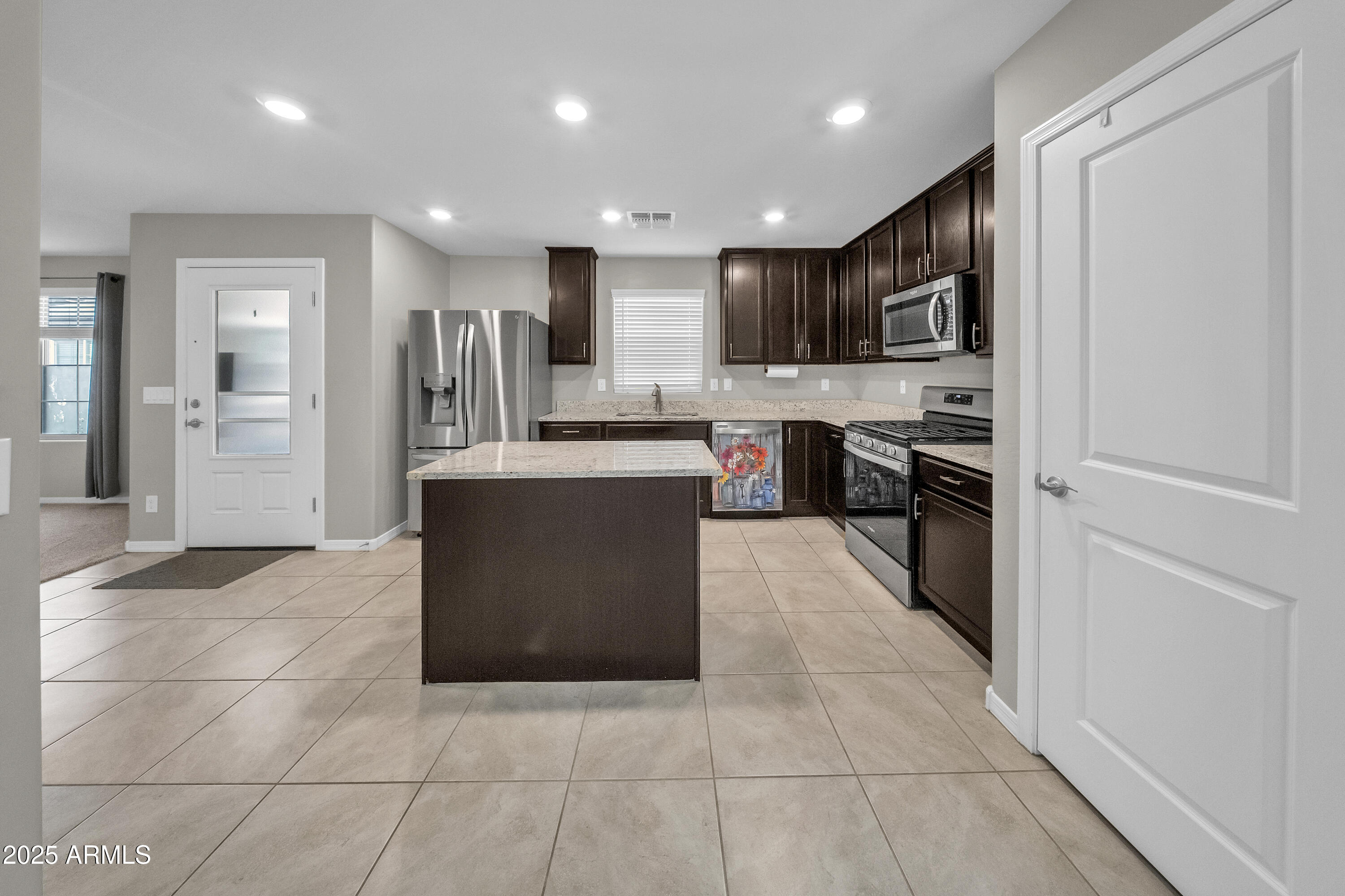 a large kitchen with stainless steel appliances granite countertop a large counter top and a stove top oven