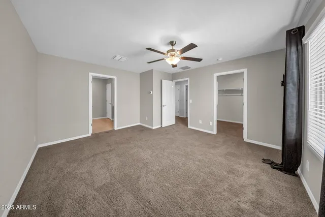 a view of a big room with chandelier fan and windows