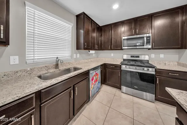 a kitchen with stainless steel appliances granite countertop a sink stove microwave and cabinets