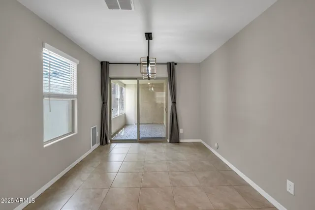 a view of empty room with window and chandelier