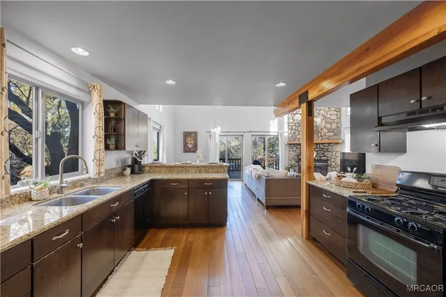 a large kitchen with stainless steel appliances granite countertop a lot of counter space and wooden floors