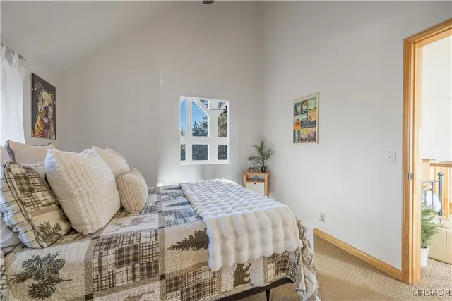 a bedroom with a bed and painting on the wall