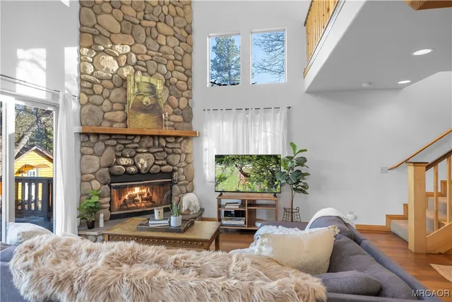 a living room with furniture a flat screen tv and a fireplace