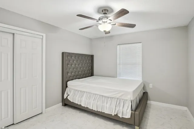 a bedroom with a bed and a ceiling fan