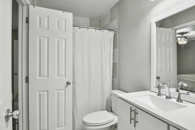 an empty room with a chandelier fan and closet area