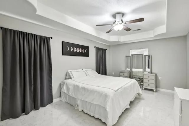 a bedroom with a large bed and a chandelier